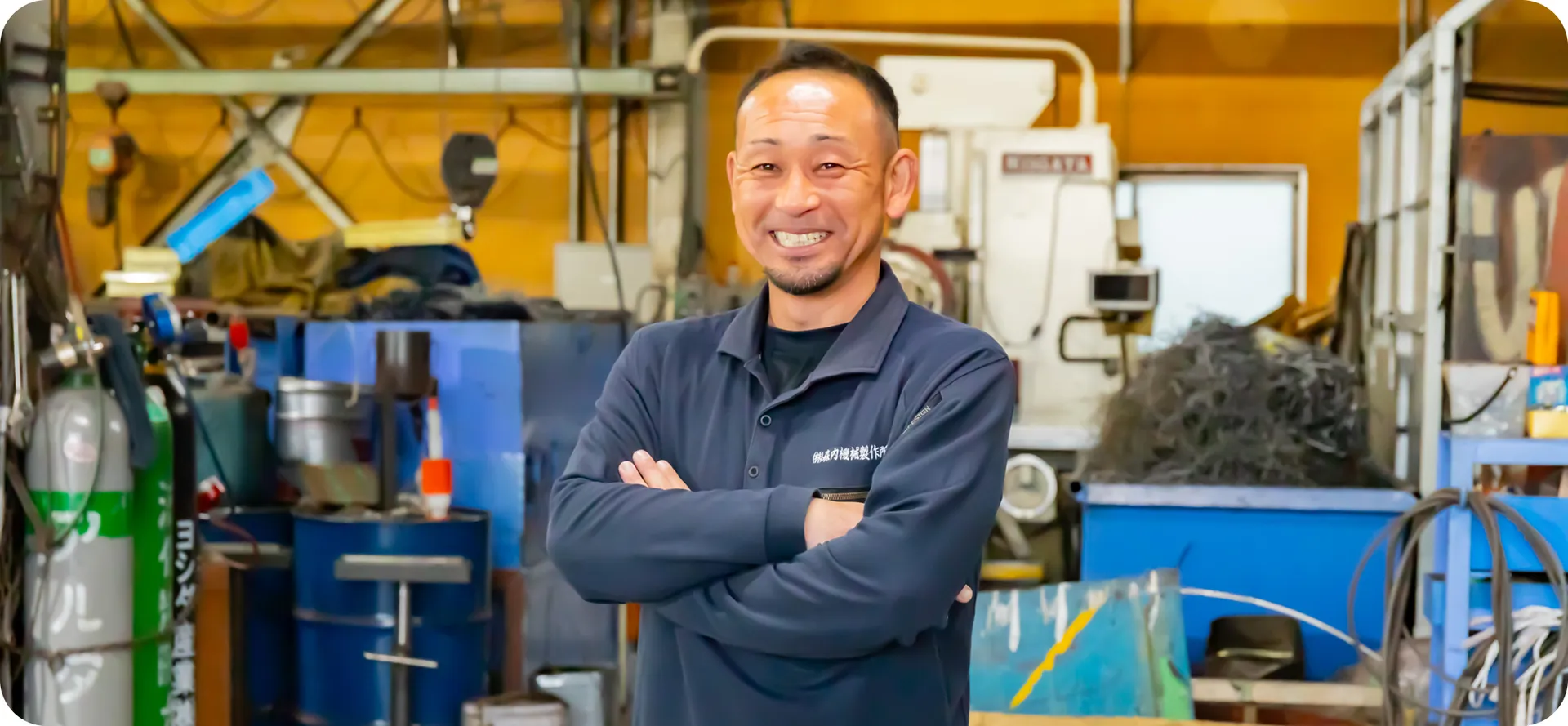 現場で働く職人が笑顔で語りかける様子。ものづくりの魅力を伝える写真